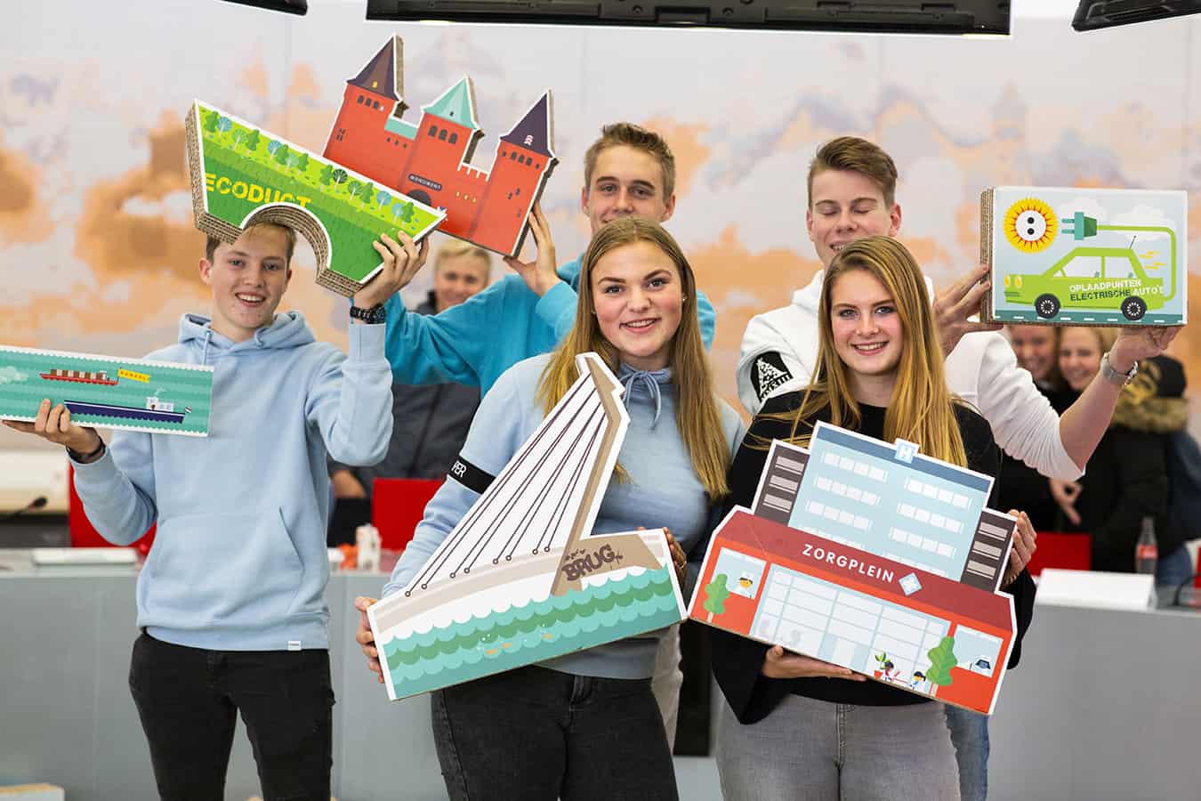 Een groep studenten houdt spelstukken van het Provinciespel omhoog