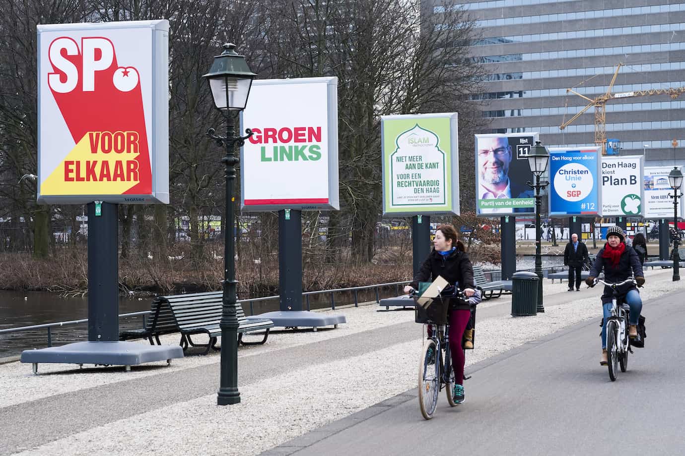 Een rij billboards met daarop steeds een grote posters van een politieke partij langs een fietspad